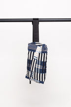 Detailansicht der ADOR BAG mit Fokus auf die diagonalen Plissees und den schwarzen Nylonriemen, hängend an einer Stange.