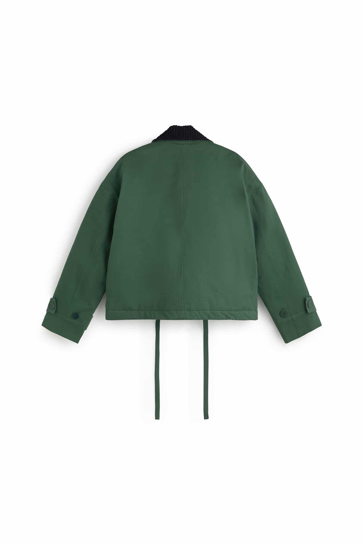 Grüne Jacke "Norma" von Thinking Mu mit dunklem Cord-Kragen, Knöpfen und herabhängenden Bändern am Saum vor hellem Hintergrund.