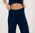 Dunkelblaue Strickhose "True Knit Wide Leg" mit weitem Bein und Kordelzug am hohen Bund, gezeigt in zwei Ansichten von vorne und hinten vor hellem Hintergrund.
