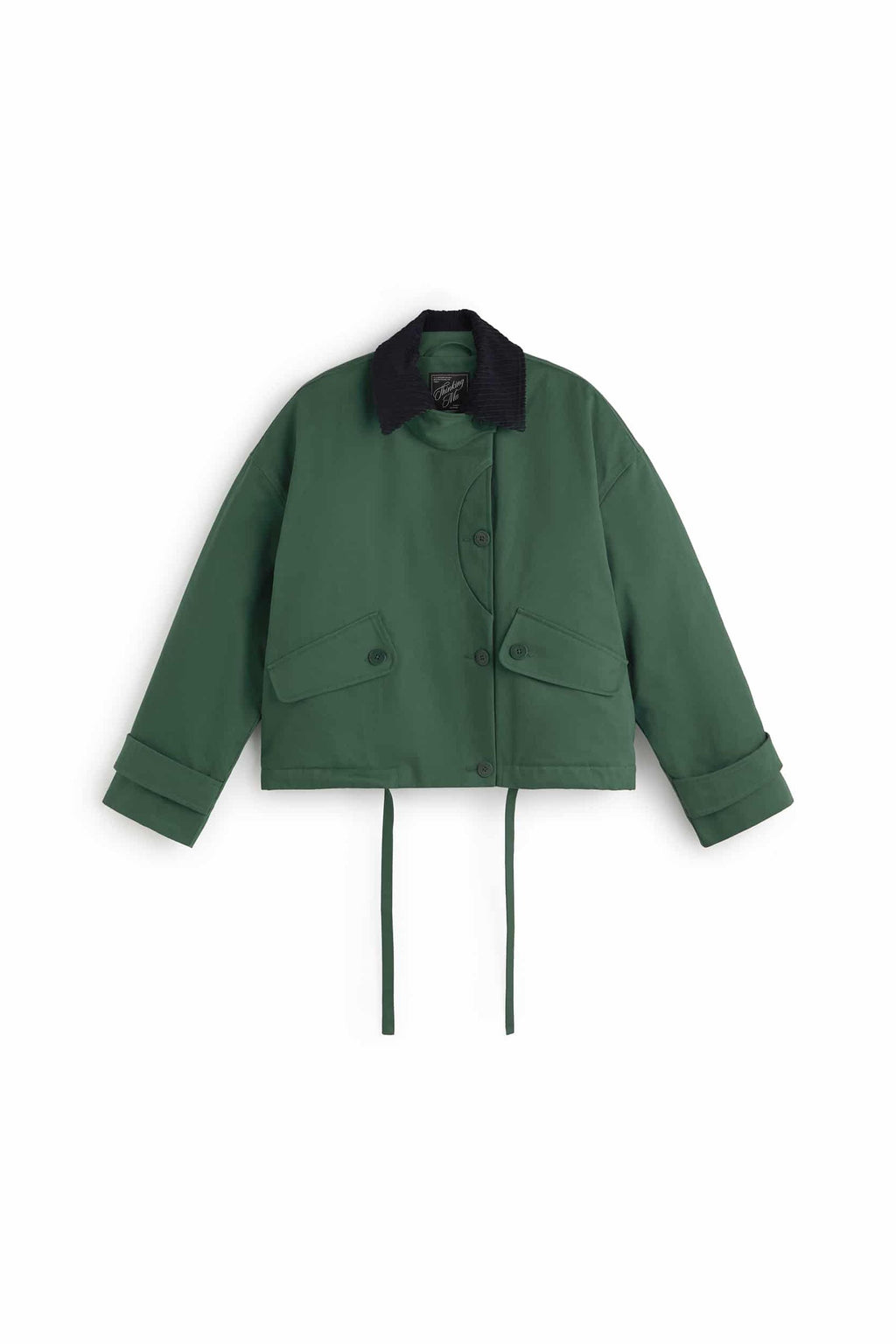 Grüne Jacke "Norma" von Thinking Mu mit dunklem Cord-Kragen, Knöpfen und herabhängenden Bändern am Saum vor hellem Hintergrund.