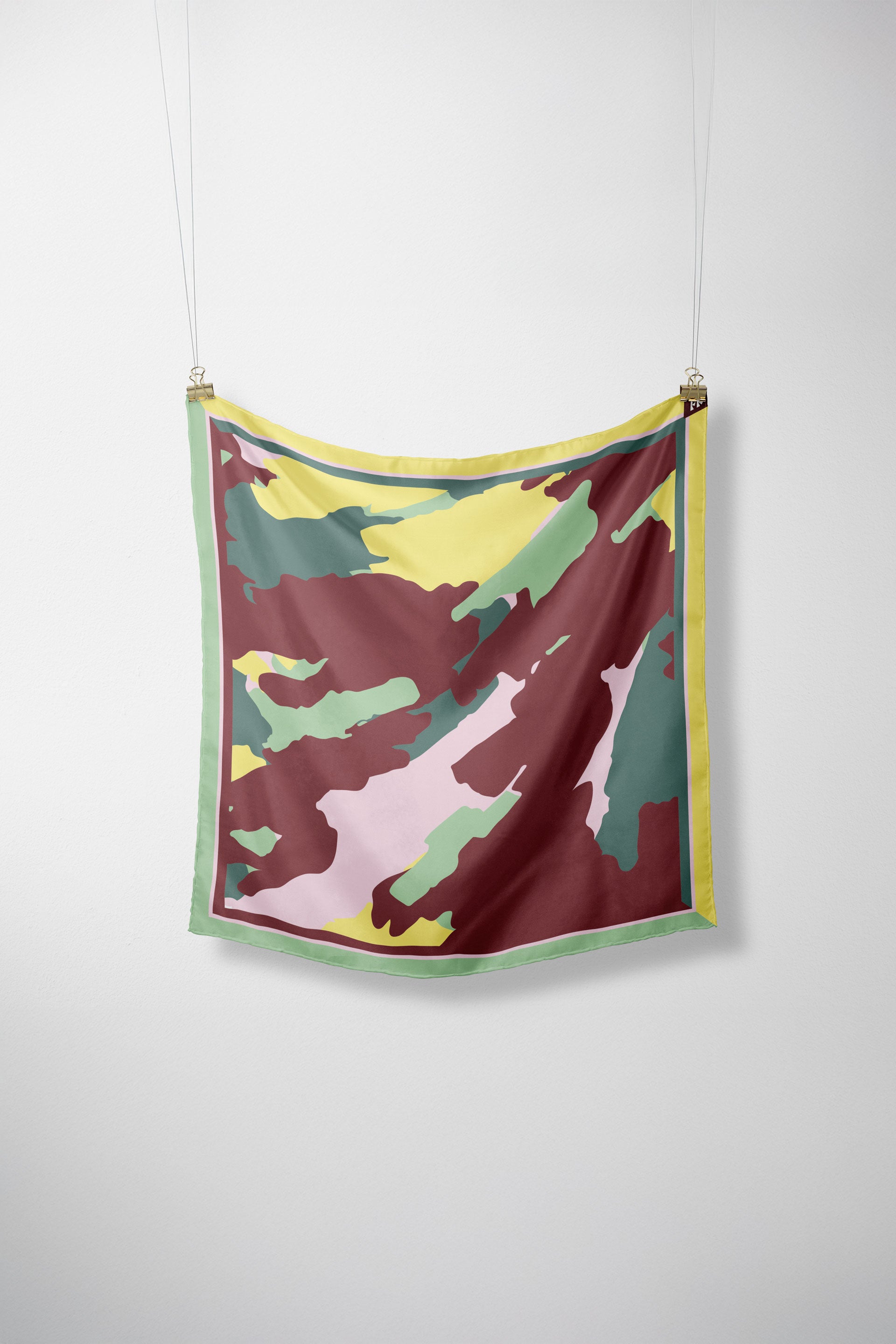 Model trägt den bunten Orbana-Gots Scarf von SKFK mit lebendigem Print elegant um den Hals gebunden zu einem dunkelroten Oberteil.