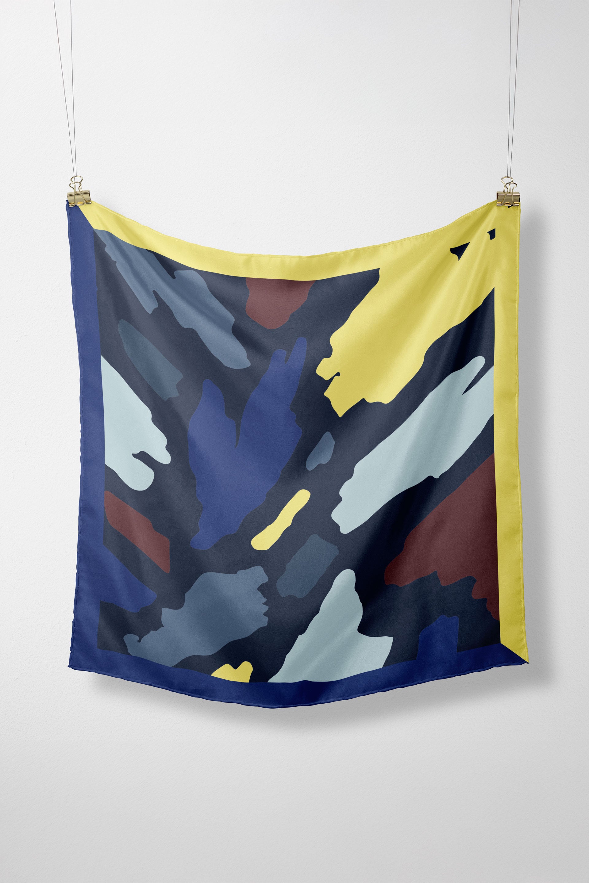 Model trägt den bunten Irura-Gots Scarf von SKFK mit markantem Print elegant um den Hals gebunden zu einem hellen Oberteil.