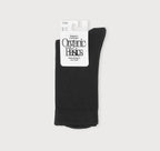 Schwarze Core Crew Socks in klassischer Crew-Länge an den Beinen eines Modells vor hellem Hintergrund.