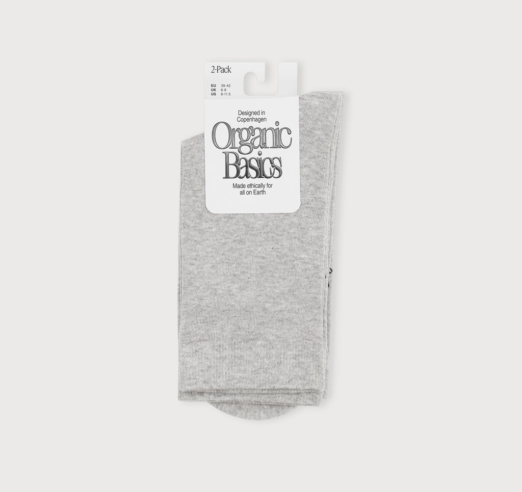 graue Core Crew Socks in klassischer Crew-Länge an den Beinen eines Modells vor hellem Hintergrund.