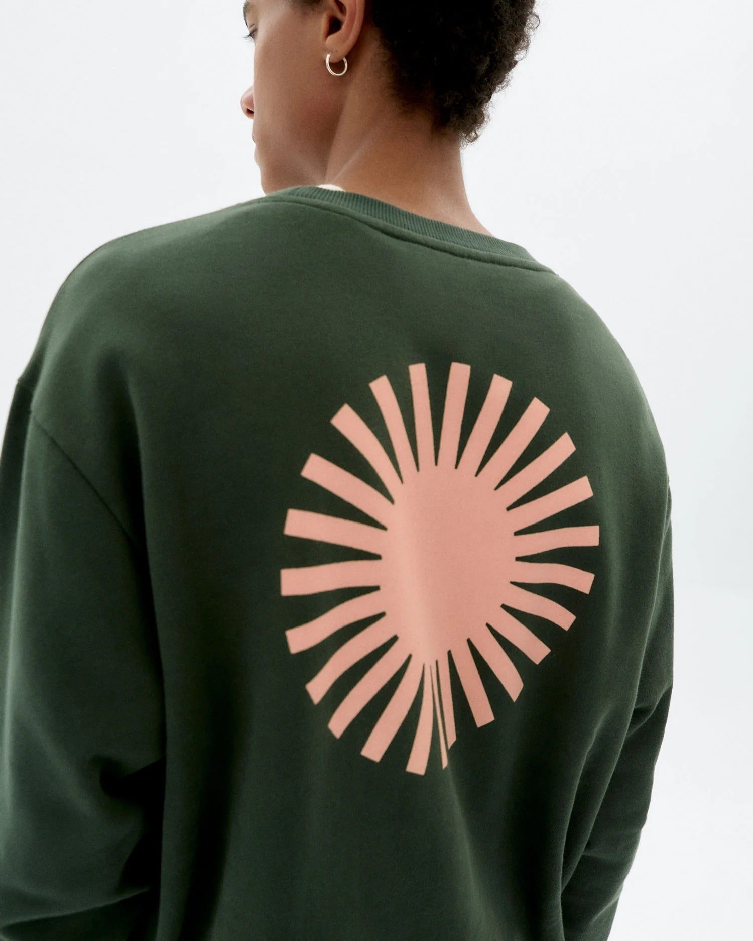 Dunkelgrünes Sweatshirt "Leon" mit rundem Halsausschnitt, kleinem Sonnen-Logo auf der Brust und großem Sonnen-Print auf der Rückseite vor hellem Hintergrund.