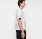 Männliches Model trägt ein graues True Extra Heavy Boxy Tee von organic basics in Misty Grey Melange mit kastenförmiger Passform.