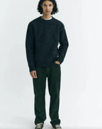 Dunkelgrüne Cordhose "David" von Thinking Mu aus feinem Cord-Stoff mit klassischen Taschen und Gürtelschlaufen vor hellem Hintergrund.