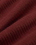Mahagonifarbene Cordhose "Hedda" aus 100% Bio-Baumwolle mit geradem Bein und aufgesetzten Taschen vor hellem Hintergrund.