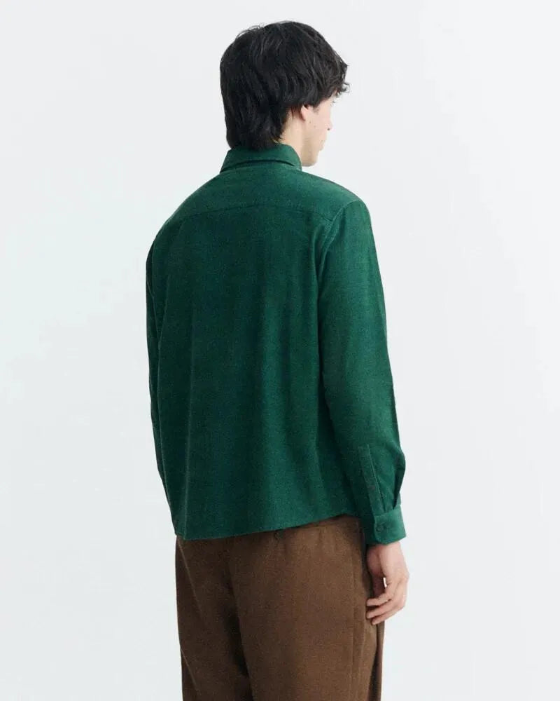 Dunkelgrünes Microcord-Hemd "Anto" von Thinking Mu mit Button-Down-Kragen, Knopfleiste und Brusttasche vor hellem Hintergrund.