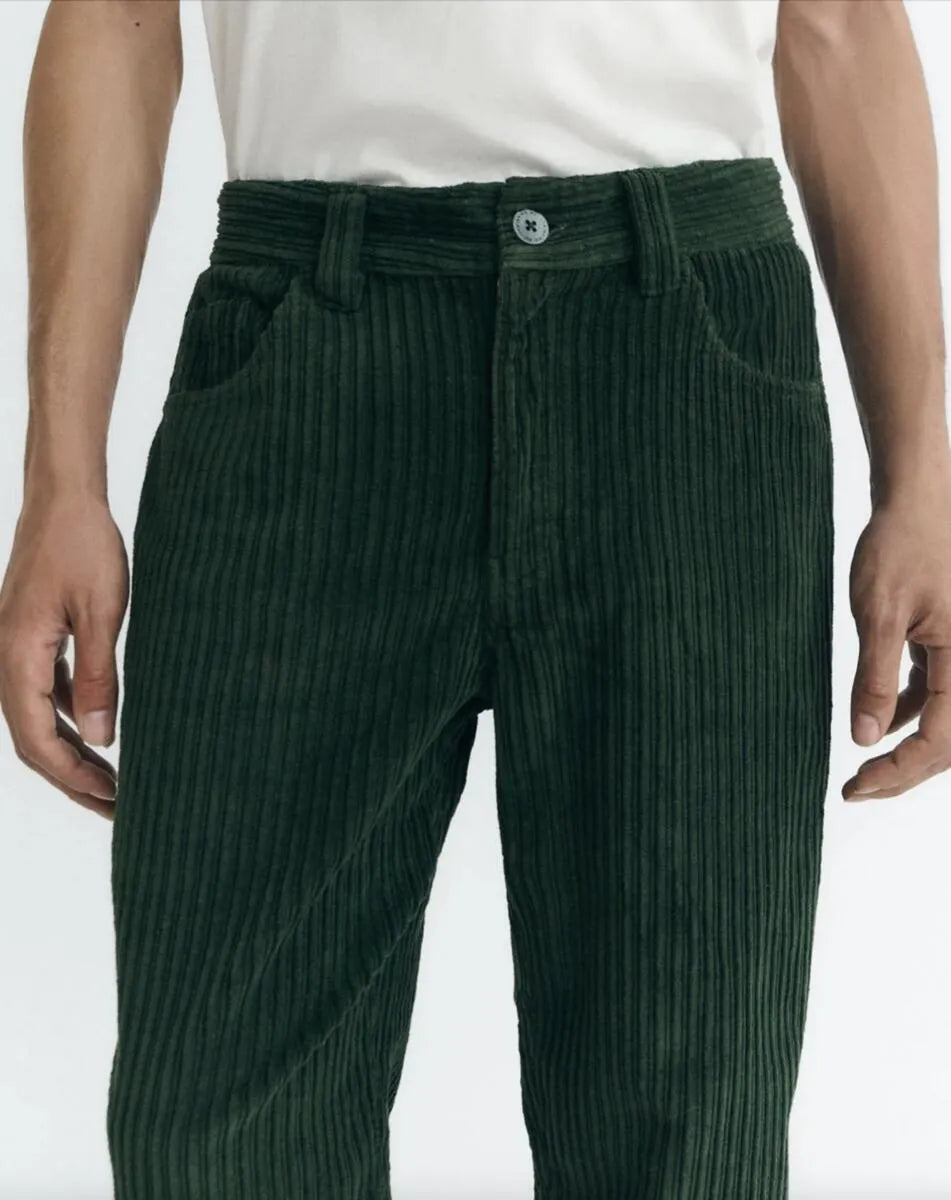 Dunkelgrüne Cordhose "David" von Thinking Mu aus feinem Cord-Stoff mit klassischen Taschen und Gürtelschlaufen vor hellem Hintergrund.