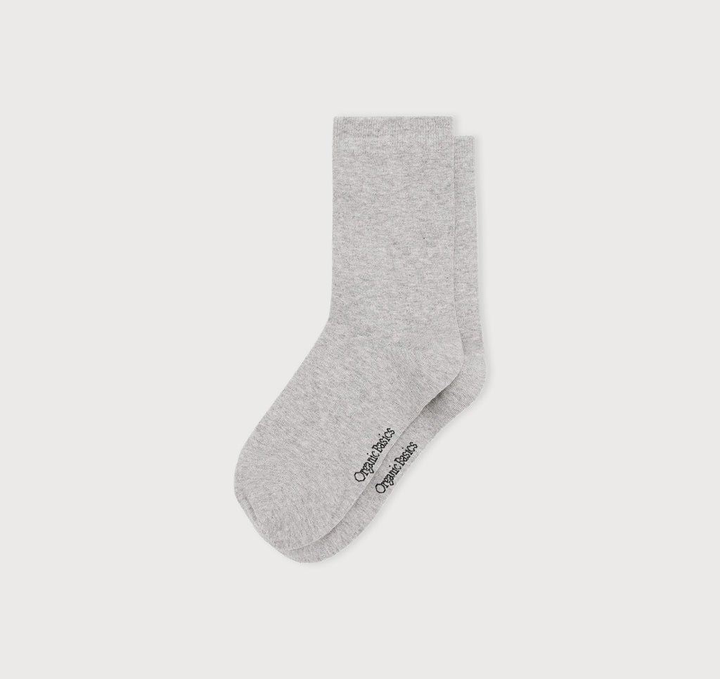 graue Core Crew Socks in klassischer Crew-Länge an den Beinen eines Modells vor hellem Hintergrund.