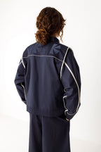 Rückansicht der HALTSU Wendejacke mit hellen Kontrastpaspeln und eingearbeitetem Logo.