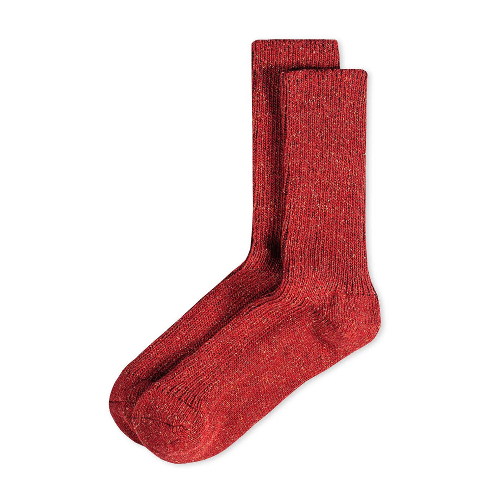 Ein Paar gestrickte Socken aus Wolle in meliertem Rot vor weißem Hintergrund. seide koblenz ferdinand