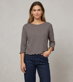 Gestreiftes Langarmshirt von Jalfe mit feinen Streifen, Rundhalsausschnitt und Wellensäumen an Ärmeln und Saum vor dunklem Hintergrund.