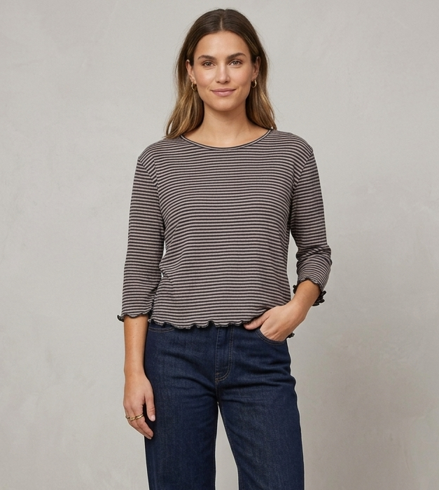 Gestreiftes Langarmshirt von Jalfe mit feinen Streifen, Rundhalsausschnitt und Wellensäumen an Ärmeln und Saum vor dunklem Hintergrund.
