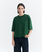 Person von vorne in einem grünen Oversized-T-Shirt "Lena" von Thinking Mu mit Rundhalsausschnitt vor hellem Hintergrund.