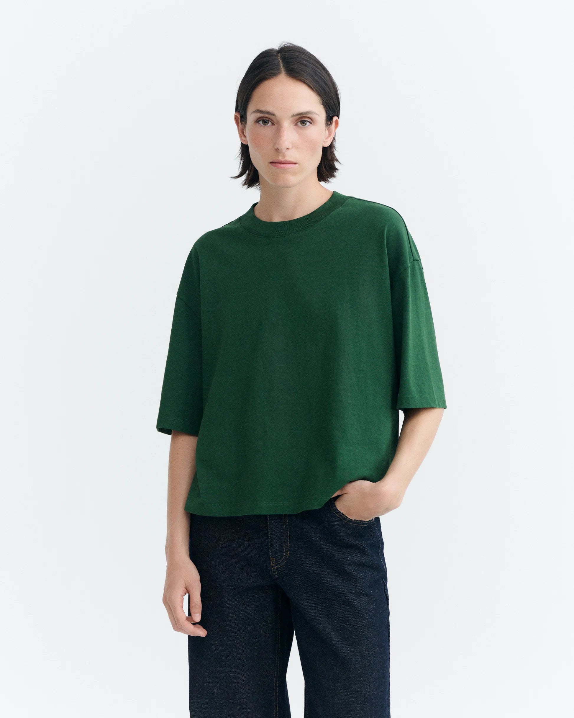 Person von vorne in einem grünen Oversized-T-Shirt "Lena" von Thinking Mu mit Rundhalsausschnitt vor hellem Hintergrund.