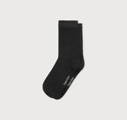 Schwarze Core Crew Socks in klassischer Crew-Länge an den Beinen eines Modells vor hellem Hintergrund.