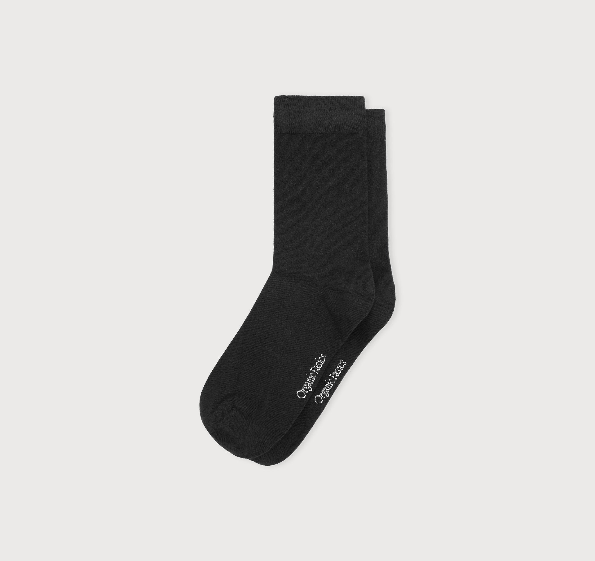 Schwarze Core Crew Socks in klassischer Crew-Länge an den Beinen eines Modells vor hellem Hintergrund.